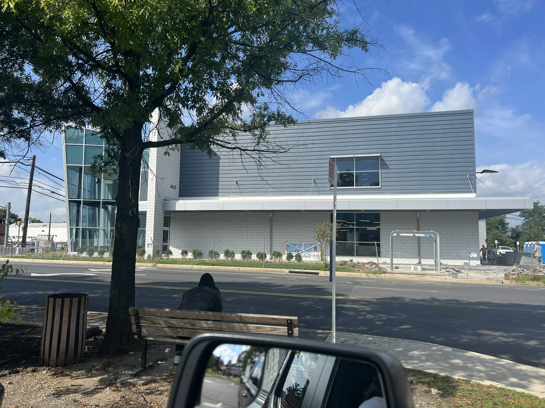 Wood-grain high-pressure laminate (HPL) rainscreen panels flanking a glazed building entrance